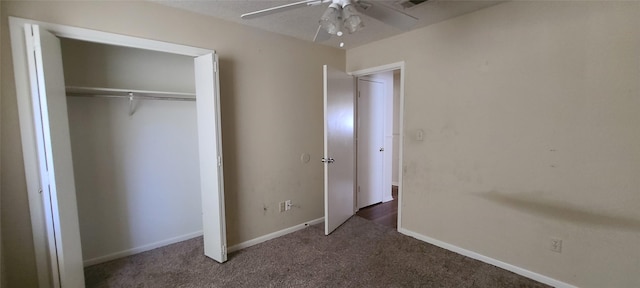 unfurnished bedroom with a closet, visible vents, dark carpet, a ceiling fan, and baseboards