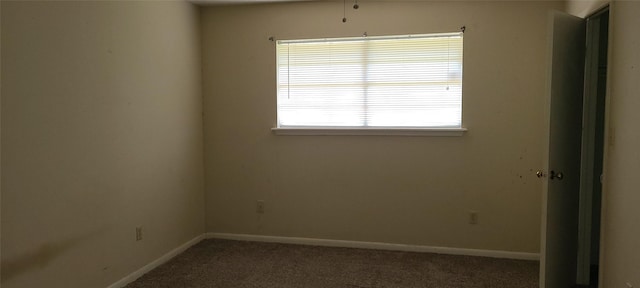 carpeted empty room featuring baseboards