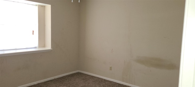 unfurnished room with carpet flooring and baseboards