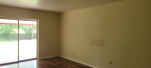 empty room featuring a textured ceiling and hardwood / wood-style flooring