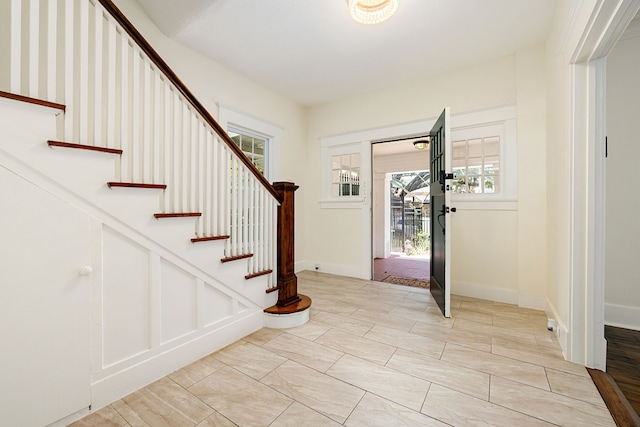 foyer entrance with baseboards and stairs