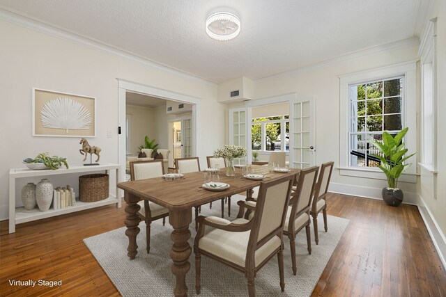 dining area with a textured ceiling, crown molding, and dark hardwood / wood-style flooring