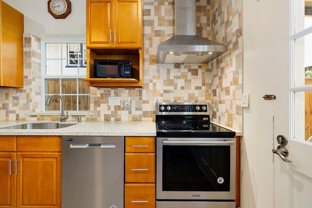 kitchen with stainless steel appliances, decorative backsplash, a sink, and wall chimney range hood