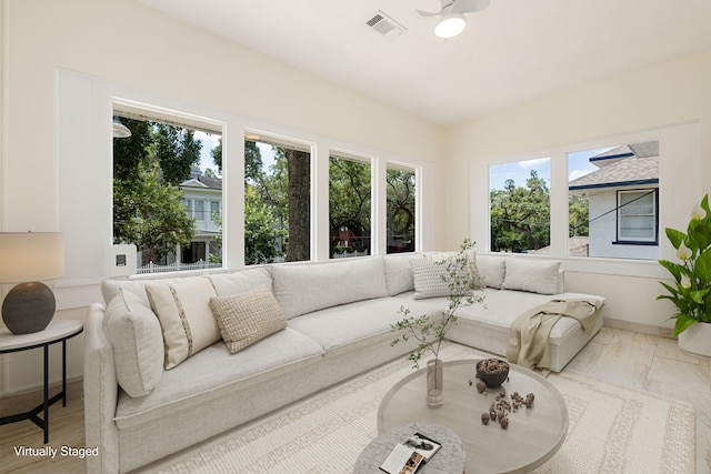 living area featuring visible vents and ceiling fan