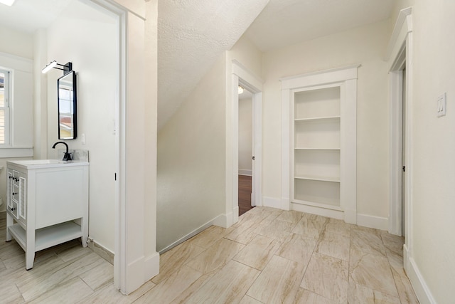 hall with a textured ceiling and sink