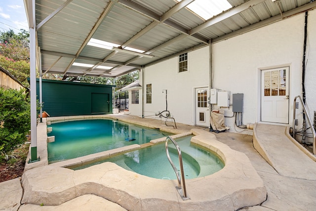 view of pool with a patio area, a pool with connected hot tub, and an outdoor structure