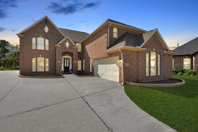 front of property featuring a garage and a yard