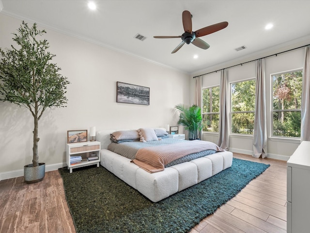 bedroom with light wood-style floors, visible vents, and crown molding