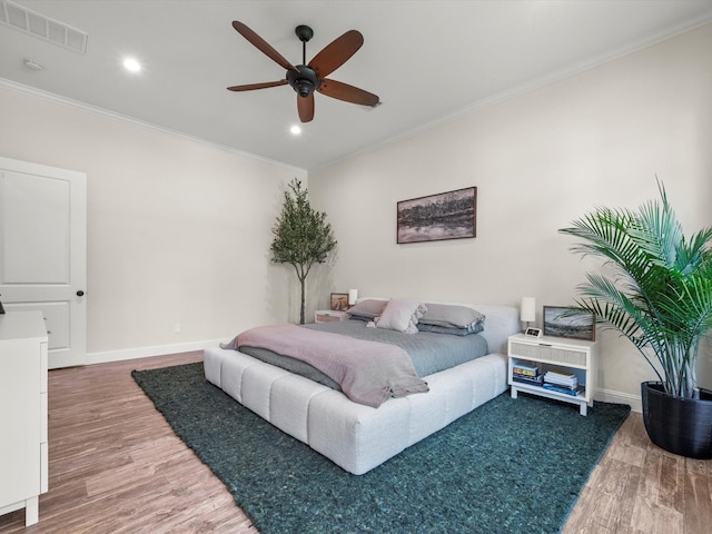 bedroom with crown molding, recessed lighting, visible vents, wood finished floors, and baseboards