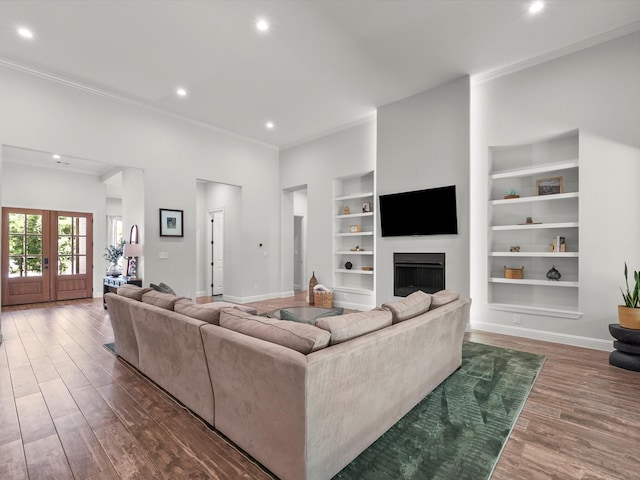 living area with built in shelves, baseboards, dark wood-type flooring, and french doors