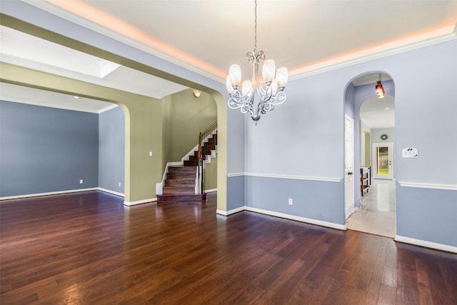 unfurnished room featuring hardwood / wood-style flooring, a notable chandelier, and crown molding