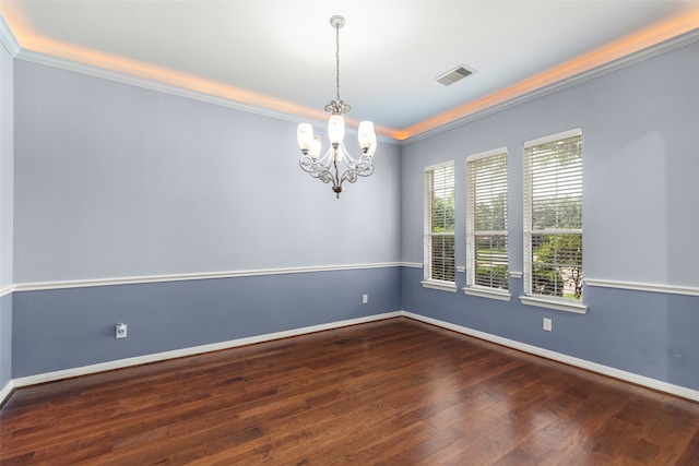 spare room featuring crown molding, wood-type flooring, and a chandelier