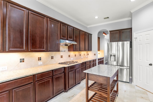 kitchen with tasteful backsplash, appliances with stainless steel finishes, and light stone countertops