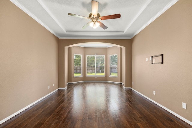 spare room with ceiling fan, a raised ceiling, ornamental molding, and dark hardwood / wood-style flooring