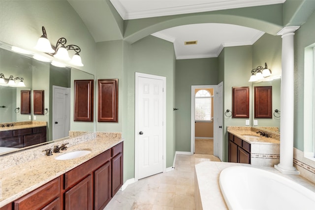 bathroom featuring ornate columns, a relaxing tiled tub, and vanity