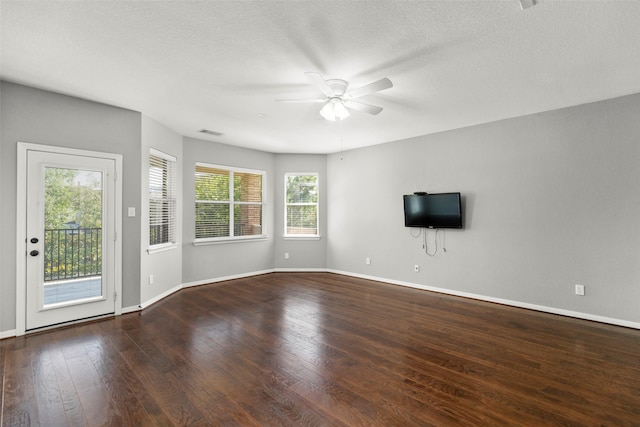 unfurnished living room with dark hardwood / wood-style flooring, a textured ceiling, and ceiling fan