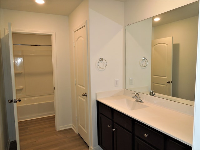 bathroom with hardwood / wood-style flooring, shower / bathtub combination, and vanity