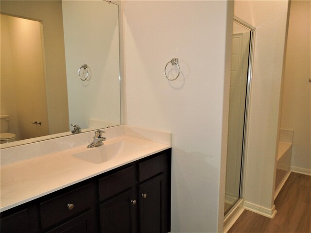 full bathroom with hardwood / wood-style floors, shower with separate bathtub, toilet, and vanity