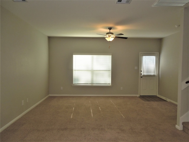 carpeted spare room with ceiling fan