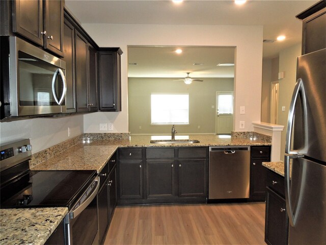 kitchen featuring sink, stainless steel appliances, light hardwood / wood-style floors, and ceiling fan