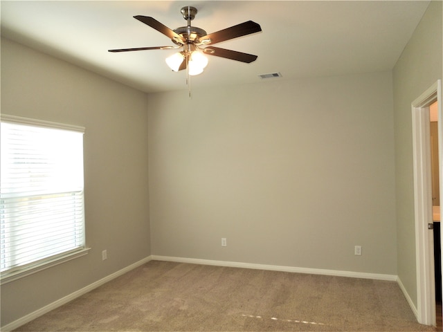 empty room featuring ceiling fan and light carpet