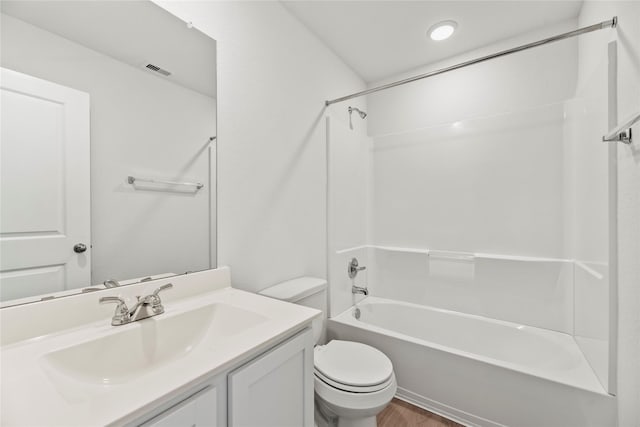 bathroom with visible vents, toilet, vanity, wood finished floors, and shower / bathtub combination