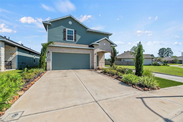 traditional-style home featuring a garage, brick siding, fence, concrete driveway, and a front yard