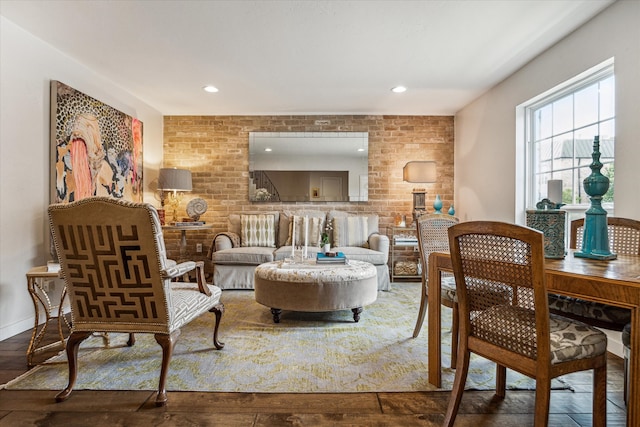 living room with wood-type flooring and brick wall