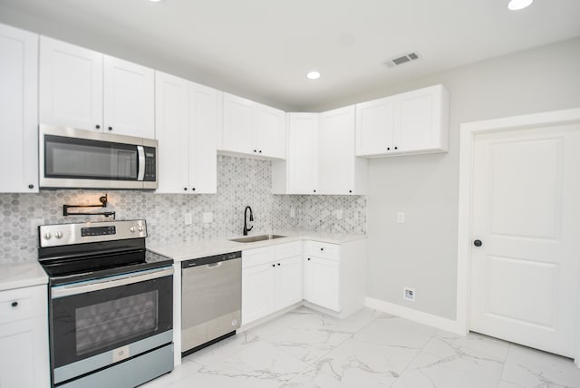 kitchen with sink, decorative backsplash, appliances with stainless steel finishes, and light tile patterned flooring