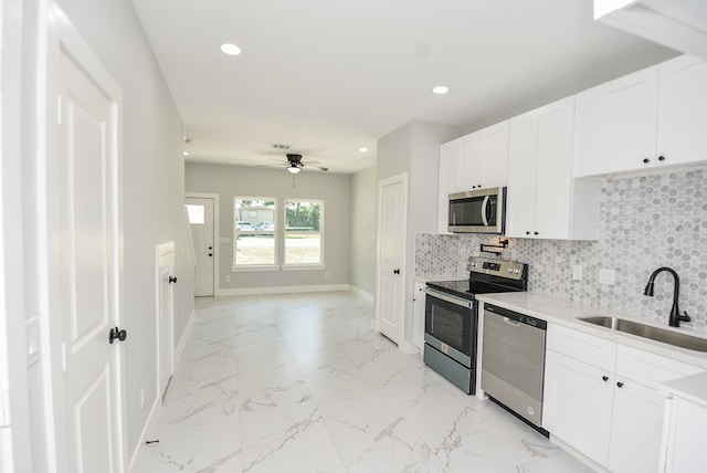 kitchen featuring stainless steel appliances, decorative backsplash, sink, ceiling fan, and light tile patterned flooring