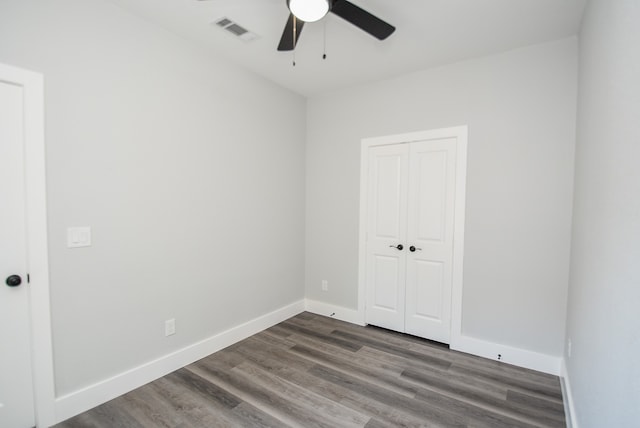 unfurnished room with ceiling fan and dark wood-type flooring