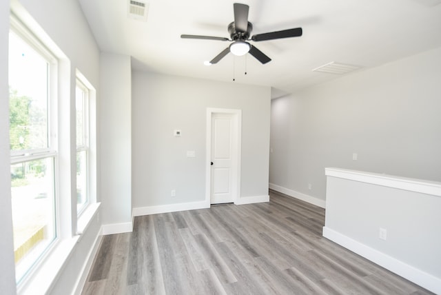 spare room with ceiling fan, light hardwood / wood-style flooring, and a wealth of natural light