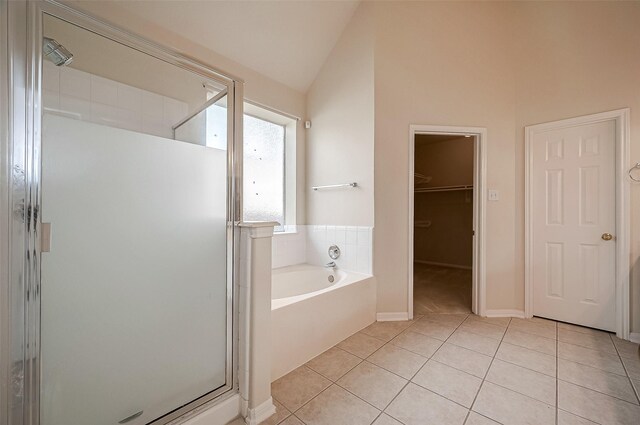 bathroom featuring plus walk in shower, vaulted ceiling, and tile patterned flooring