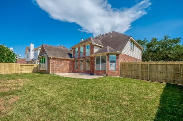 rear view of property with a patio area and a yard