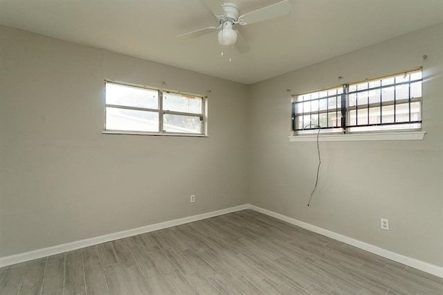 spare room featuring hardwood / wood-style flooring, plenty of natural light, and ceiling fan