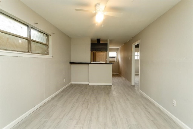 empty room with ceiling fan and light hardwood / wood-style floors