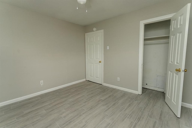 unfurnished bedroom featuring light hardwood / wood-style flooring, ceiling fan, and a closet