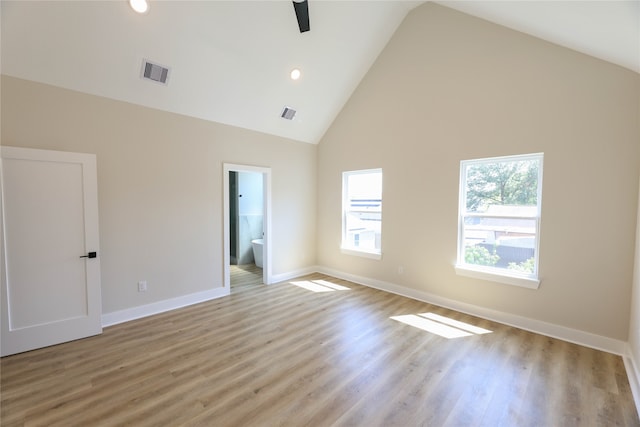 empty room featuring ceiling fan, light wood-type flooring, and high vaulted ceiling