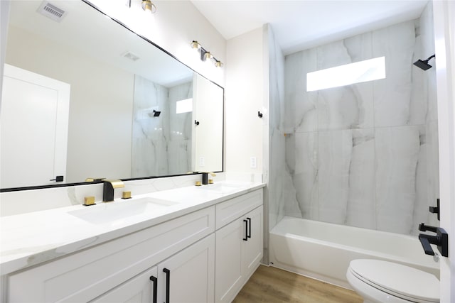 full bathroom with wood-type flooring, vanity, toilet, and tiled shower / bath