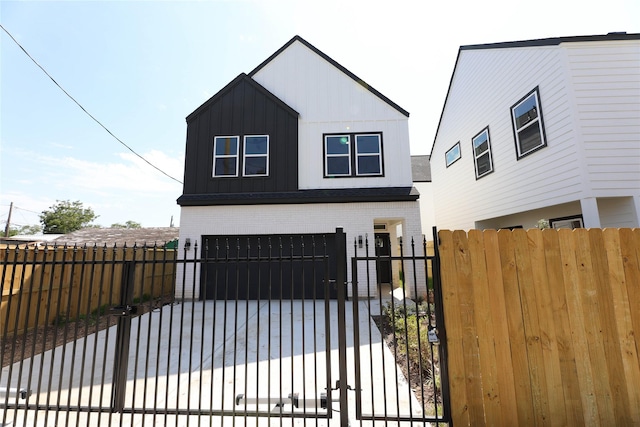 view of front facade with a fenced front yard, brick siding, driveway, a gate, and board and batten siding