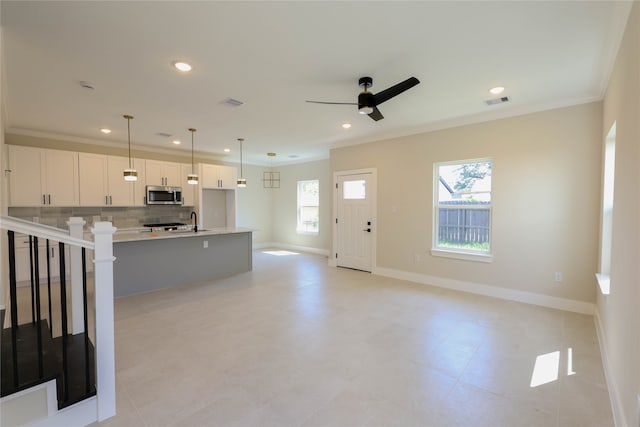 kitchen with pendant lighting, white cabinetry, an island with sink, and plenty of natural light