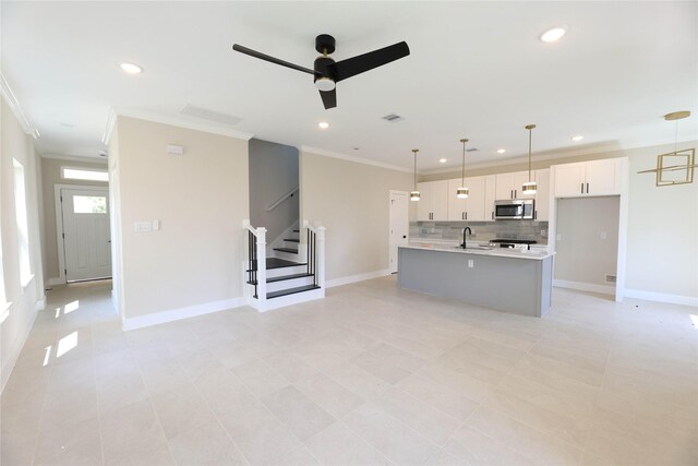 unfurnished living room featuring crown molding, sink, light tile patterned floors, and ceiling fan