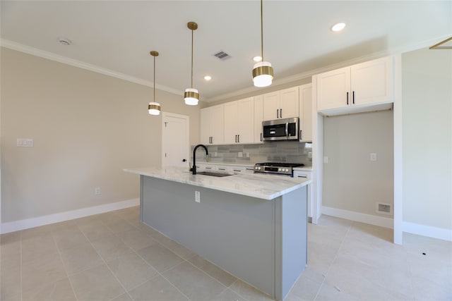 kitchen featuring light stone counters, hanging light fixtures, sink, a kitchen island with sink, and stainless steel appliances