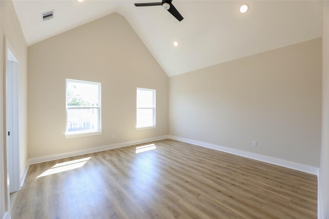 empty room featuring high vaulted ceiling, light wood-type flooring, and ceiling fan