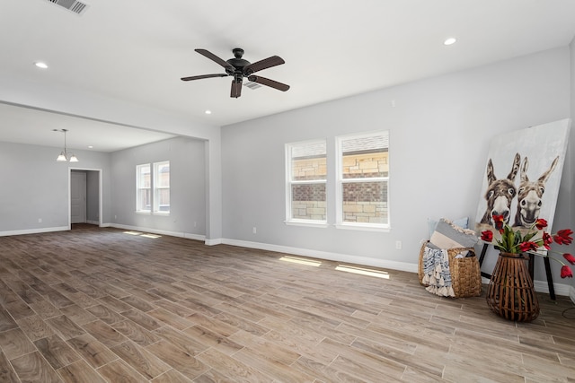 interior space featuring ceiling fan, baseboards, and wood finished floors