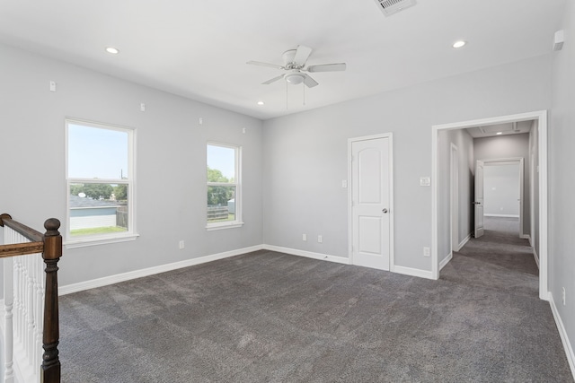 unfurnished bedroom with dark carpet and ceiling fan