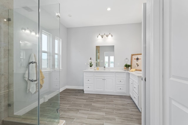 bathroom featuring wood-type flooring, a shower with shower door, and vanity