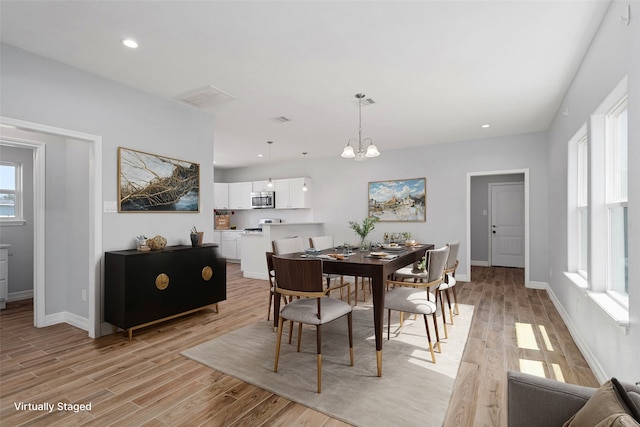 dining room featuring light hardwood / wood-style flooring and a notable chandelier