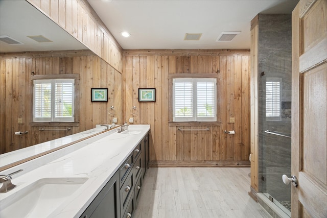 bathroom featuring vanity, hardwood / wood-style flooring, wood walls, and an enclosed shower