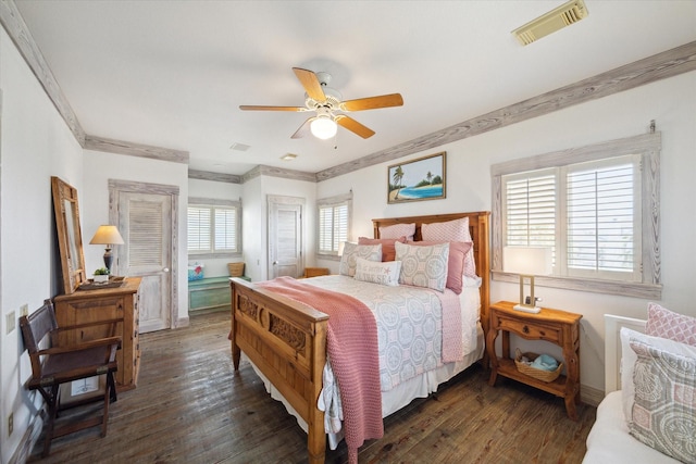 bedroom with ceiling fan, wood finished floors, visible vents, and ornamental molding